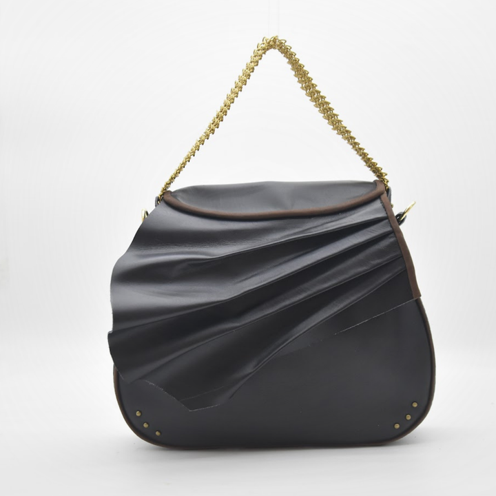 ISIS saddle bag in draped, sculpted black leather with a brass chain in gold, front view, Patricia Bos Designs