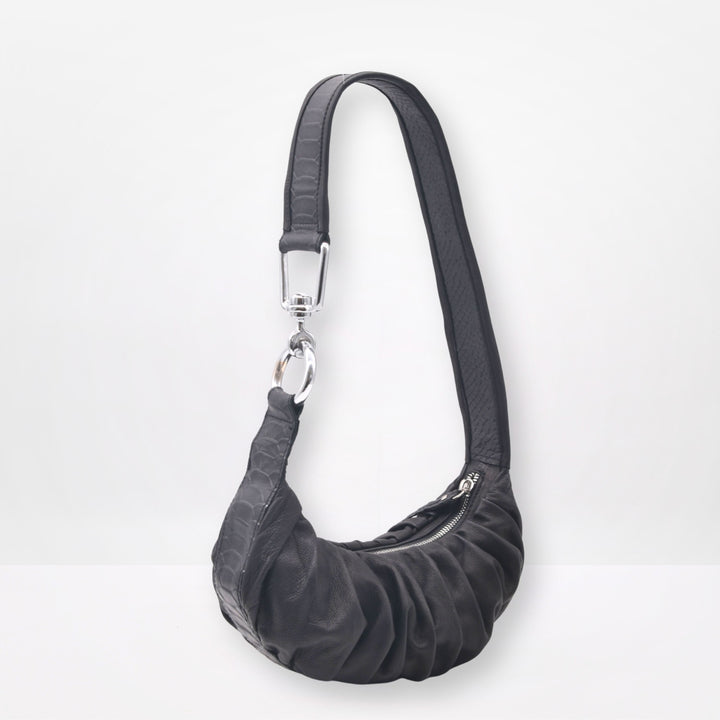 Black shoulder bag with a strap on a white background