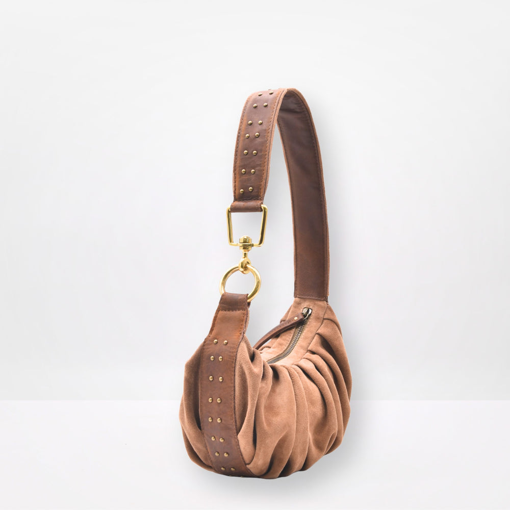 Brown suede handbag with gold accents on a white background