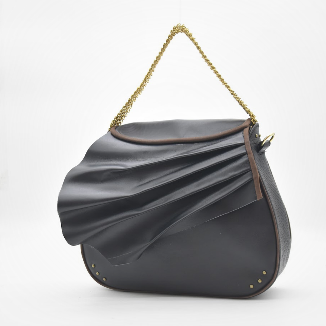 ISIS black leather saddle bag carried as a handbag, sculpted leather wave