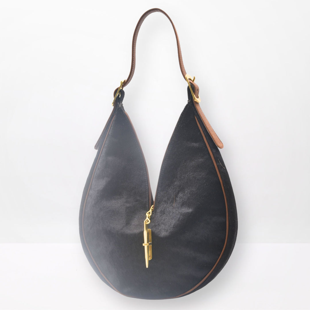 Round sculptural shoulder bag in dark brown cowhide with gold-brass hardware and signature closing system, handmade by Patricia Bos Designs.